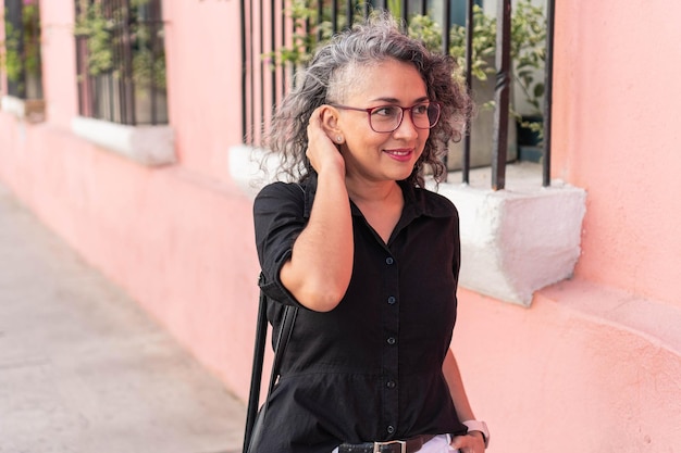 Mujer mayor moderna caminando por la calle