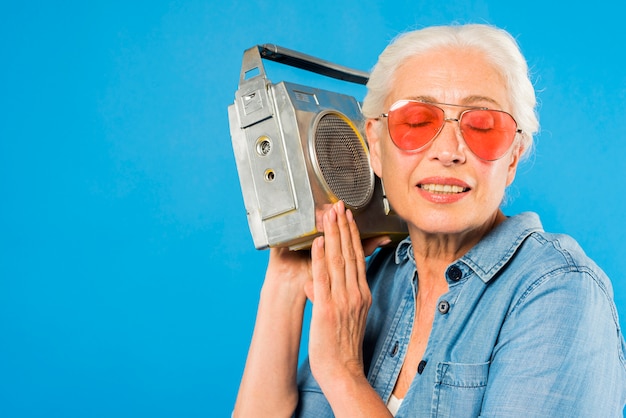 Foto mujer mayor moderna con radio vintage