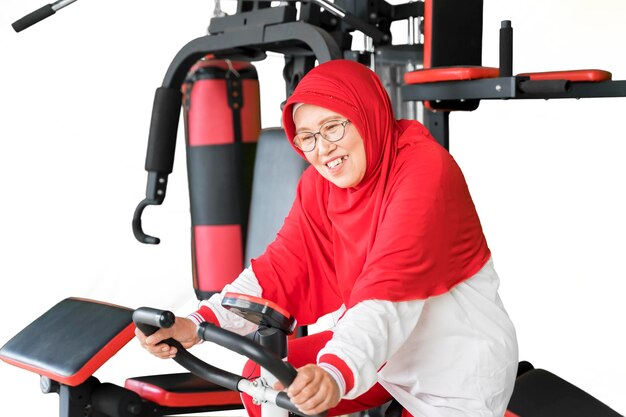 Mujer mayor musulmana montando bicicleta estática