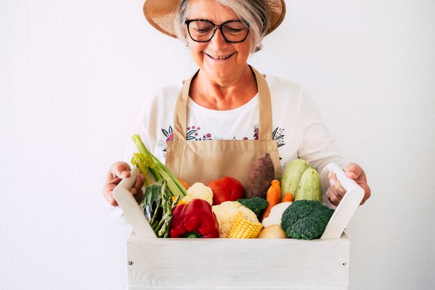 Una mujer mayor orgullosa muestra la cosecha de su huerto listo para la venta