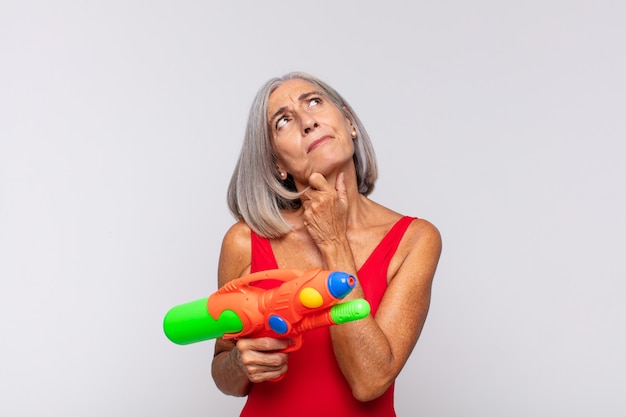 mujer mayor, con, un, pistola de agua