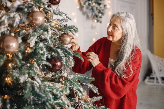 mujer mayor, posición, y, decoración, árbol de navidad