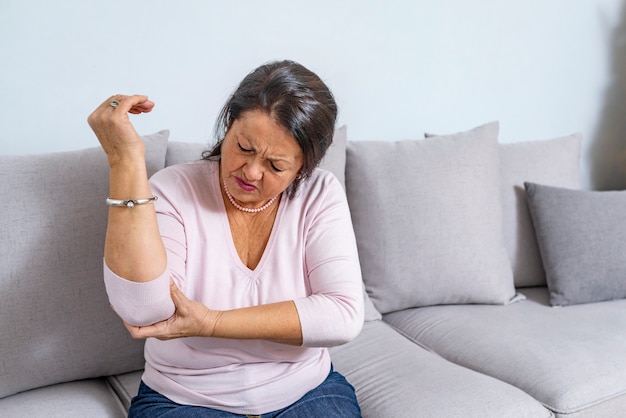 Mujer mayor que sufre de dolor a disposición en casa.