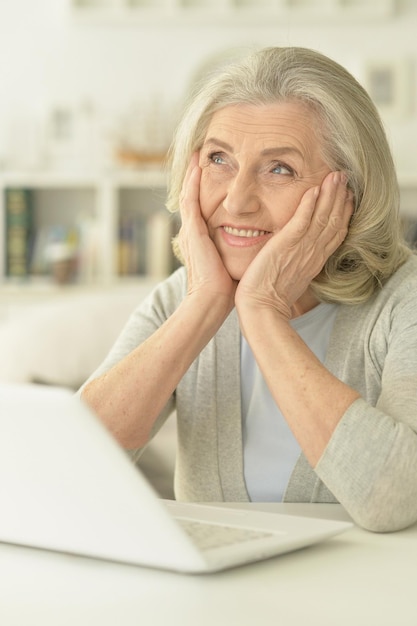 Mujer mayor que usa la computadora portátil
