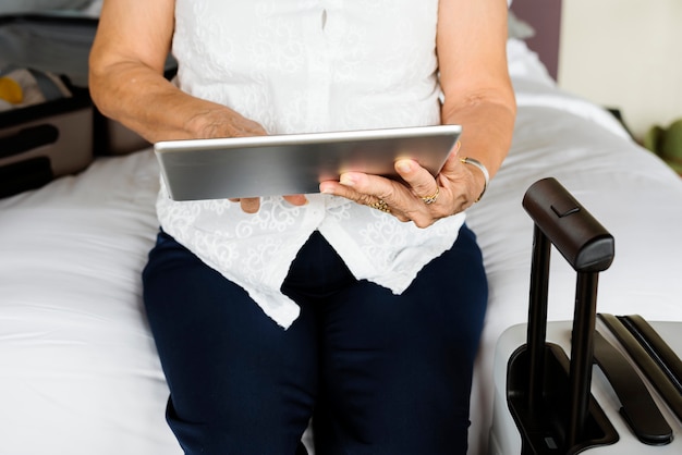 Foto mujer mayor que usa la tableta en una cama