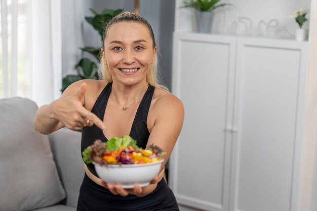Mujer mayor sana en ropa deportiva sosteniendo un plato de frutas y verduras Estilo de vida vegano y nutrición de cocina saludable para el concepto de físico corporal físico Clout