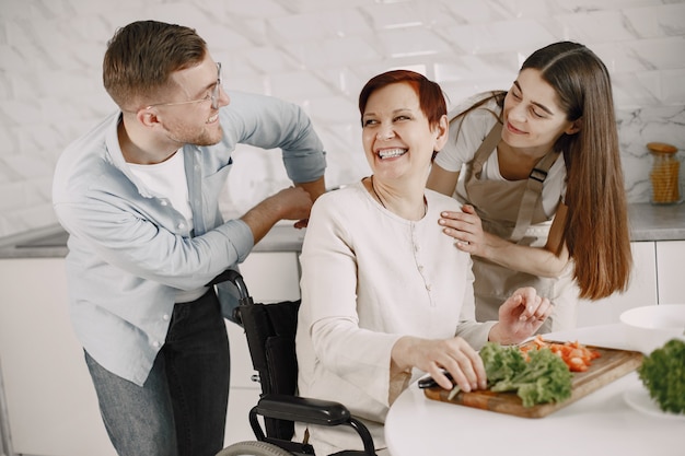 Mujer mayor en silla de ruedas cocinando en la cocina. Personas con discapacidad Pareja ayudándola.