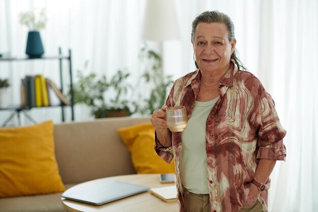 Foto mujer mayor con una taza de agua