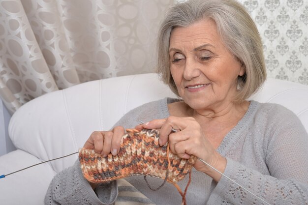 Mujer mayor, tejer, en, sofá, en casa