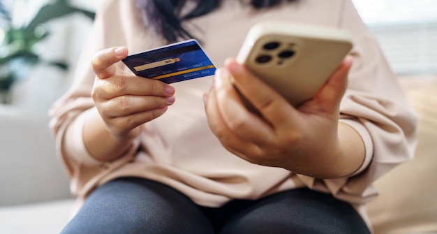 Mujer mayor con teléfono inteligente para compras en línea Mano que sostiene el teléfono móvil con Pago con tarjeta de crédito Compras en línea Monedero electrónico Pago Compras por teléfono y concepto de tarjeta conectada