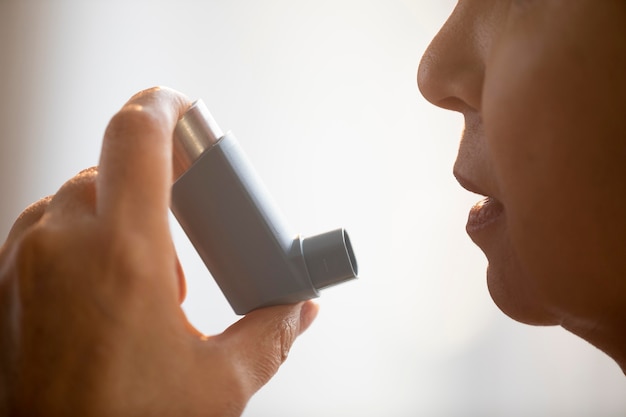 Foto mujer mayor, tenencia, asma, inhalador