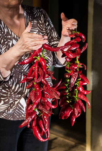 Foto mujer mayor, tenencia, pimiento rojo, en el jardín
