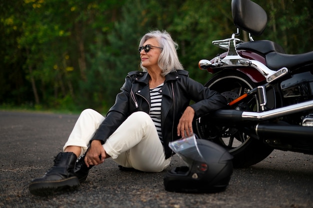 Foto mujer mayor de tiro completo con motocicleta