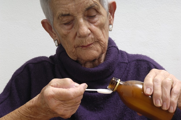 Foto mujer mayor, tomar, jarabe