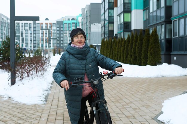 Una mujer mayor viaja por un sendero para bicicletas en invierno