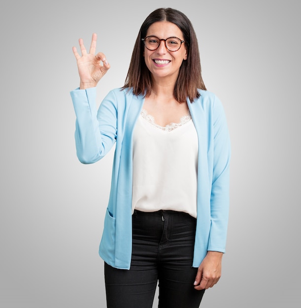 Mujer de mediana edad, alegre y segura, haciendo un gesto aceptable, excitada y gritando