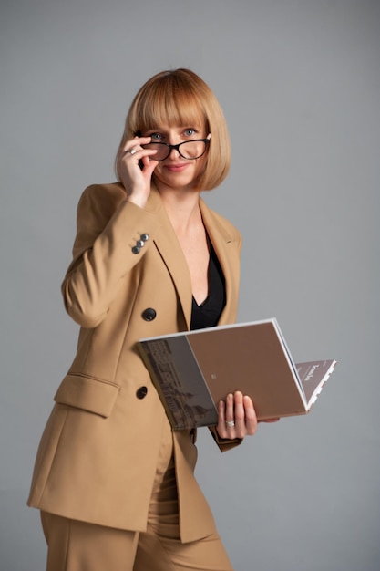 Mujer de mediana edad con anteojos y libro.