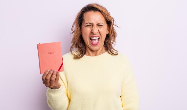 Mujer de mediana edad bastante gritando agresivamente, mirando muy enojado. concepto de agenda