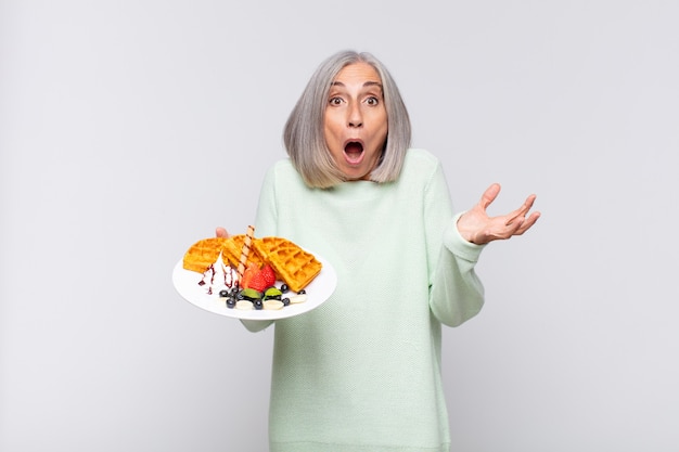 Mujer de mediana edad con la boca abierta y asombrada