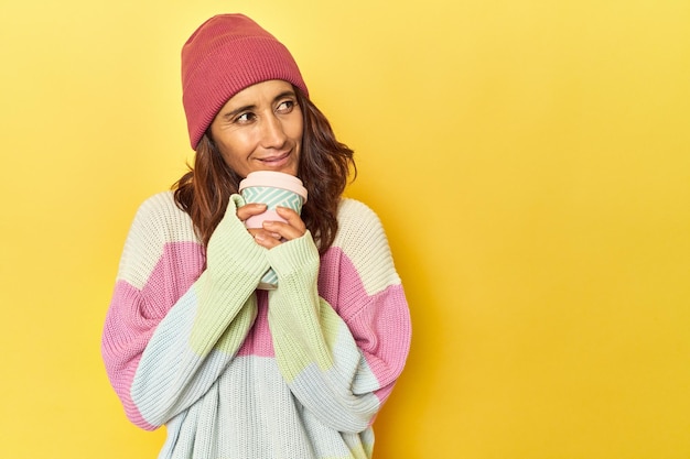 Foto mujer de mediana edad con café para llevar en amarillo