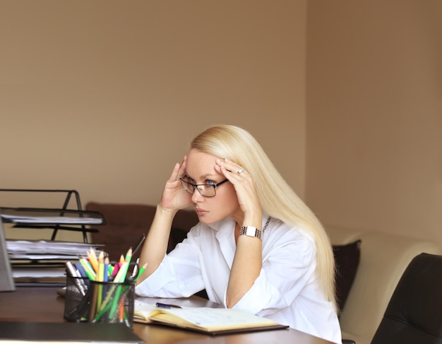 Una mujer de mediana edad cansada de trabajar en su oficina