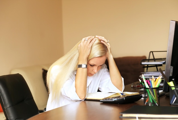 Una mujer de mediana edad cansada de trabajar en su oficina