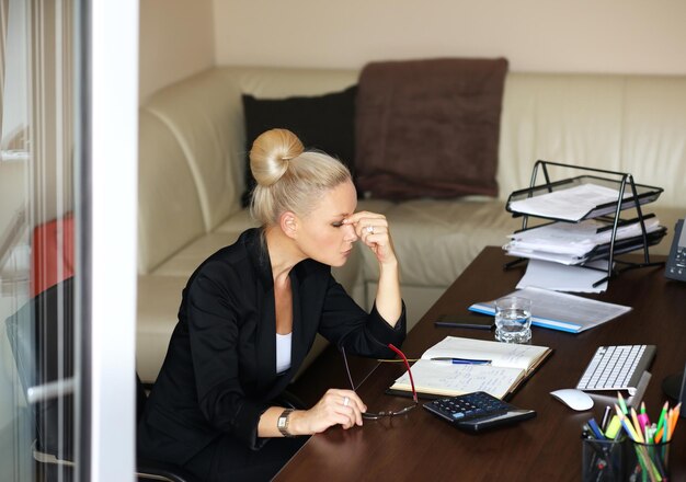 Una mujer de mediana edad cansada de trabajar en su oficina