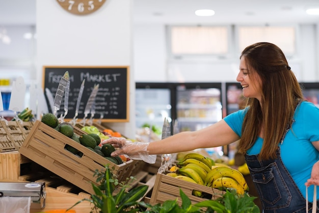 Mujer de mediana edad comprando frutas y verduras