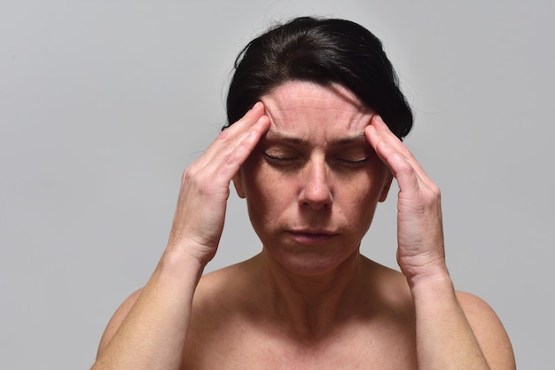 Mujer de mediana edad con dolor de cabeza.