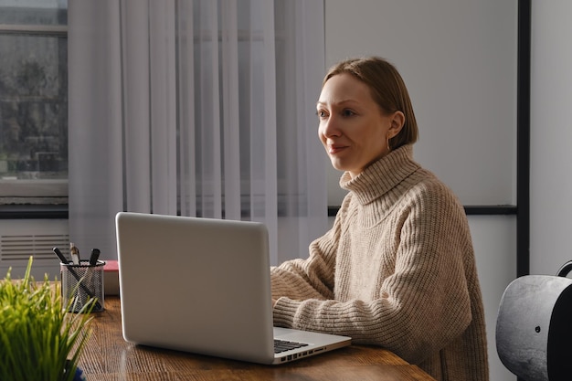 Mujer de mediana edad enamorada de su trabajo trabaja en la oficina a altas horas de la noche