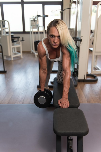 Foto mujer de mediana edad haciendo ejercicio de peso pesado para la espalda con pesas en fitness centar