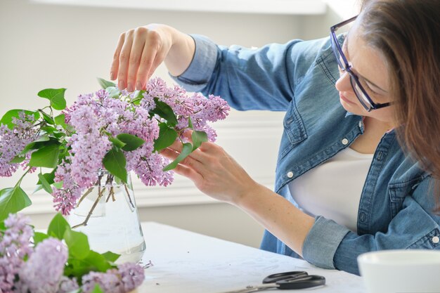 Mujer de mediana edad haciendo ramo de ramas lilas