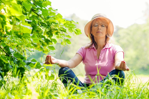 Mujer de mediana edad haciendo yoga meditación