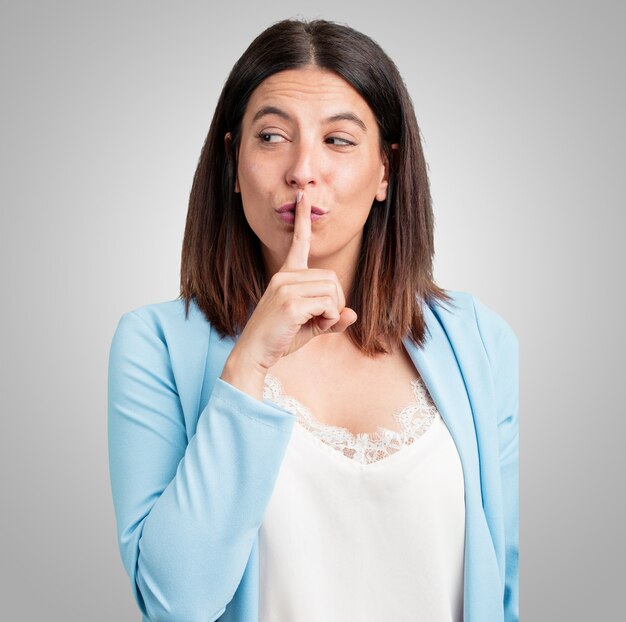 Foto mujer de mediana edad manteniendo un secreto o pidiendo silencio, rostro serio, concepto de obediencia