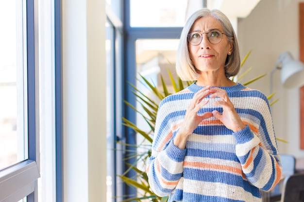 Mujer de mediana edad maquinando y conspirando, pensando en trucos y trampas tortuosas, astuta y traicionando