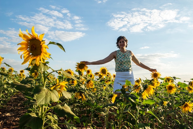 Mujer de mediana edad en una plantación de girasol