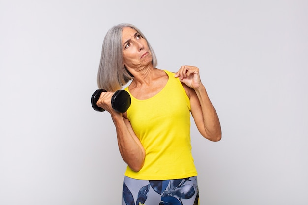 Mujer de mediana edad que parece arrogante, exitosa, positiva y orgullosa, apuntando a sí misma. concepto de fitness