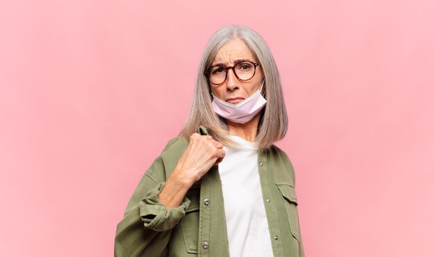 Mujer de mediana edad que parece arrogante, exitosa, positiva y orgullosa, apuntando a sí misma