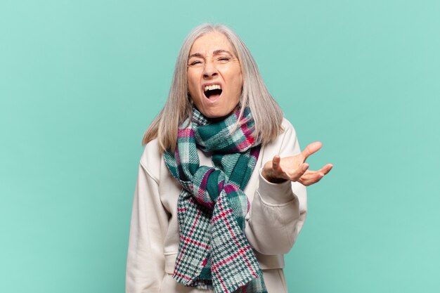 Mujer de mediana edad que parece enojada, molesta y frustrada gritando wtf o qué te pasa