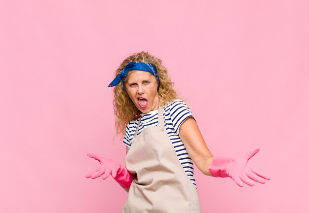 Foto mujer de mediana edad que parece feliz, arrogante, orgullosa y satisfecha de sí misma, sintiéndose como un concepto de ama de llaves número uno