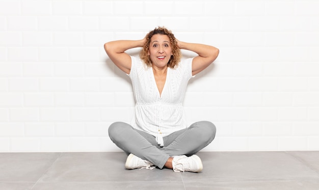 Mujer de mediana edad que parece feliz, despreocupada, amigable y relajada disfrutando de la vida y el éxito, con una actitud positiva