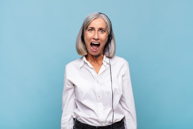 Mujer de mediana edad que parece muy conmocionada o sorprendida, mirando con la boca abierta diciendo wow. concepto de telemarketer