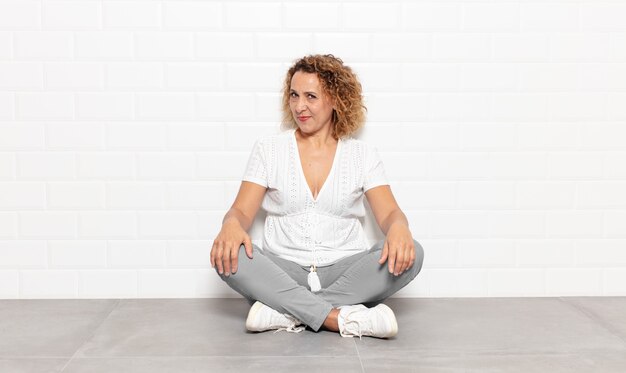 Mujer de mediana edad que parece orgullosa, segura de sí misma, fresca, descarada y arrogante, sonriente, sintiéndose exitosa