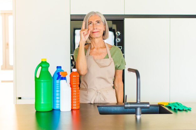 Mujer de mediana edad que se siente como un genio levantando el dedo con orgullo en el aire después de darse cuenta de una gran idea, diciendo eureka