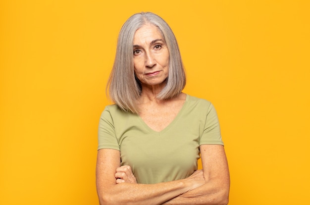 Mujer de mediana edad que se siente disgustada y decepcionada, con aspecto serio, molesto y enojado con los brazos cruzados.