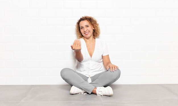 Mujer de mediana edad que se siente feliz, exitosa y segura, enfrenta un desafío y dice ¡adelante! o dándote la bienvenida