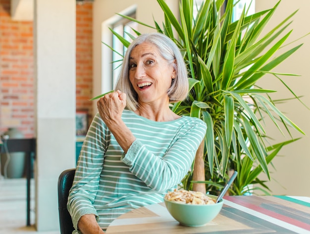 Mujer de mediana edad que se siente feliz, positiva y exitosa, motivada al enfrentar un desafío o celebrar buenos resultados.