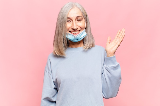 Mujer de mediana edad que se siente feliz, sorprendida y alegre, sonriendo con actitud positiva, dándose cuenta de una solución o idea