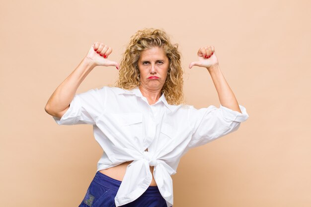 Mujer de mediana edad que se siente orgullosa, arrogante y segura, luciendo satisfecha y exitosa, apuntando a sí misma