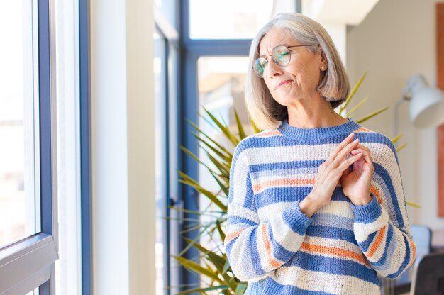 Mujer de mediana edad que se siente orgullosa, traviesa y arrogante mientras planea un plan malvado o piensa en un truco